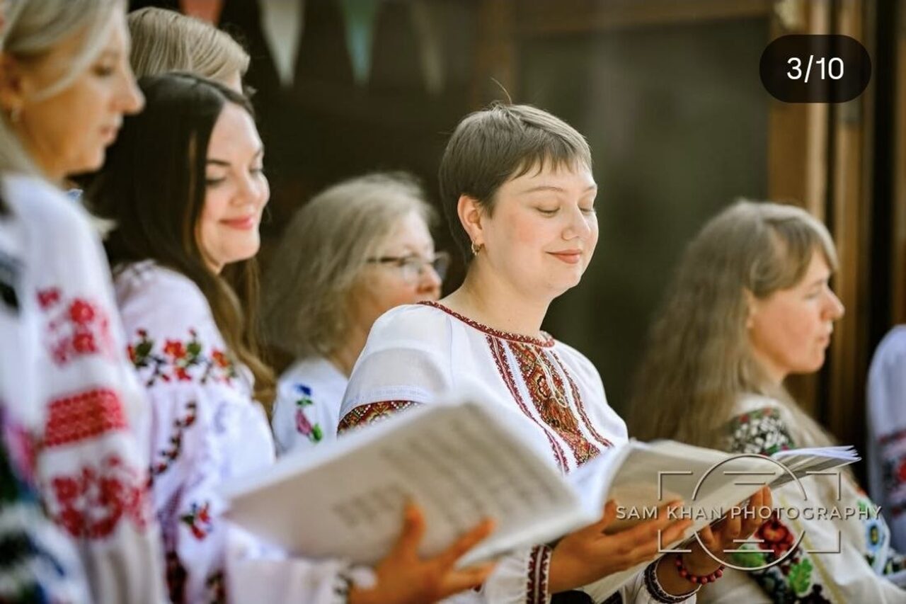 A choir member sings with her eyes closed, holding her music