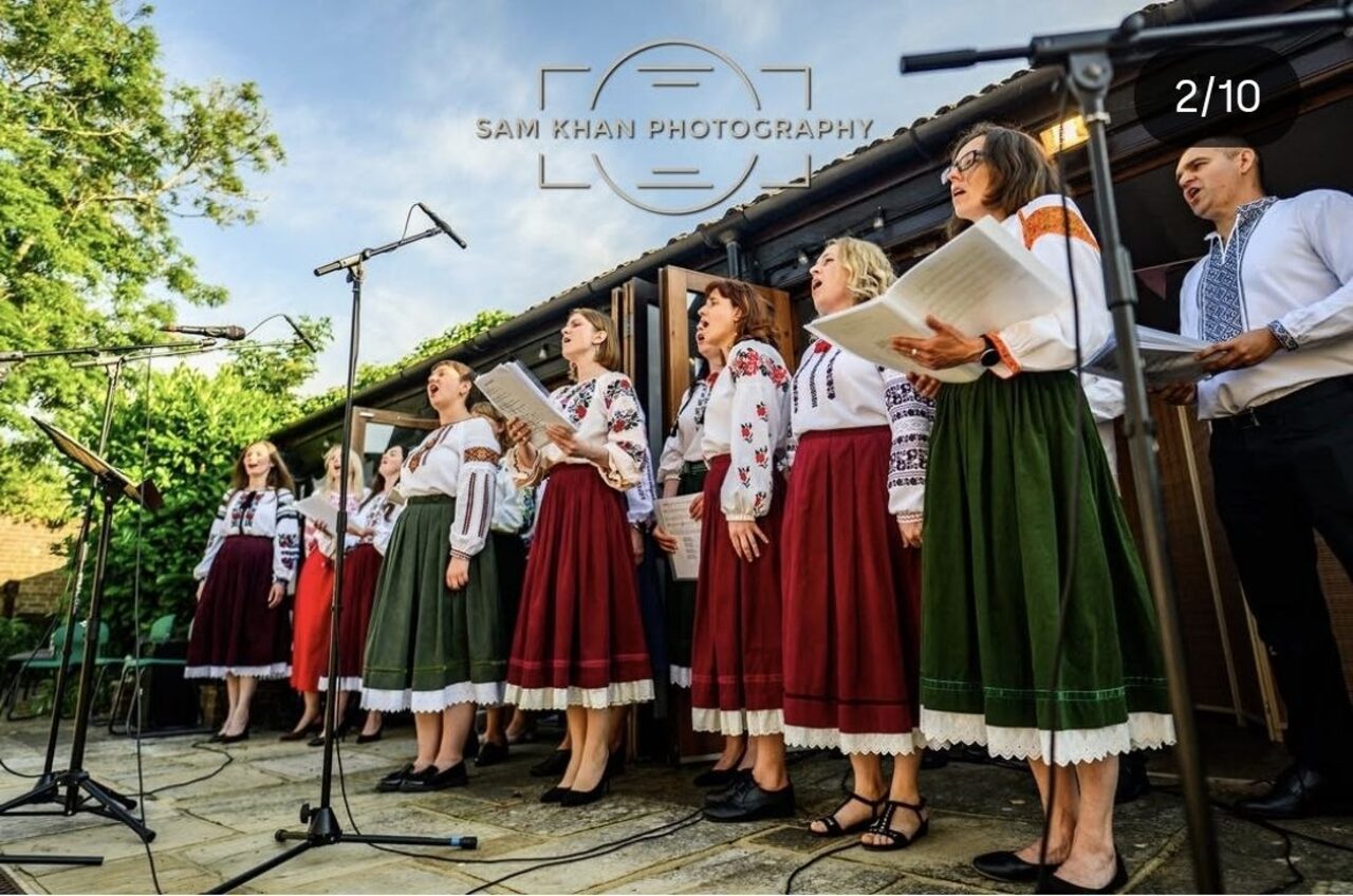 Ukrainian Voices choir singing outdoors in the evening light.